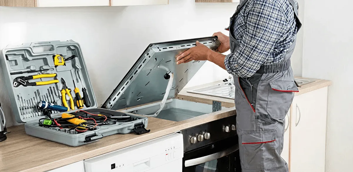 Handyman repairing a cooktop and checking wiring connections in Bloomington, IN
