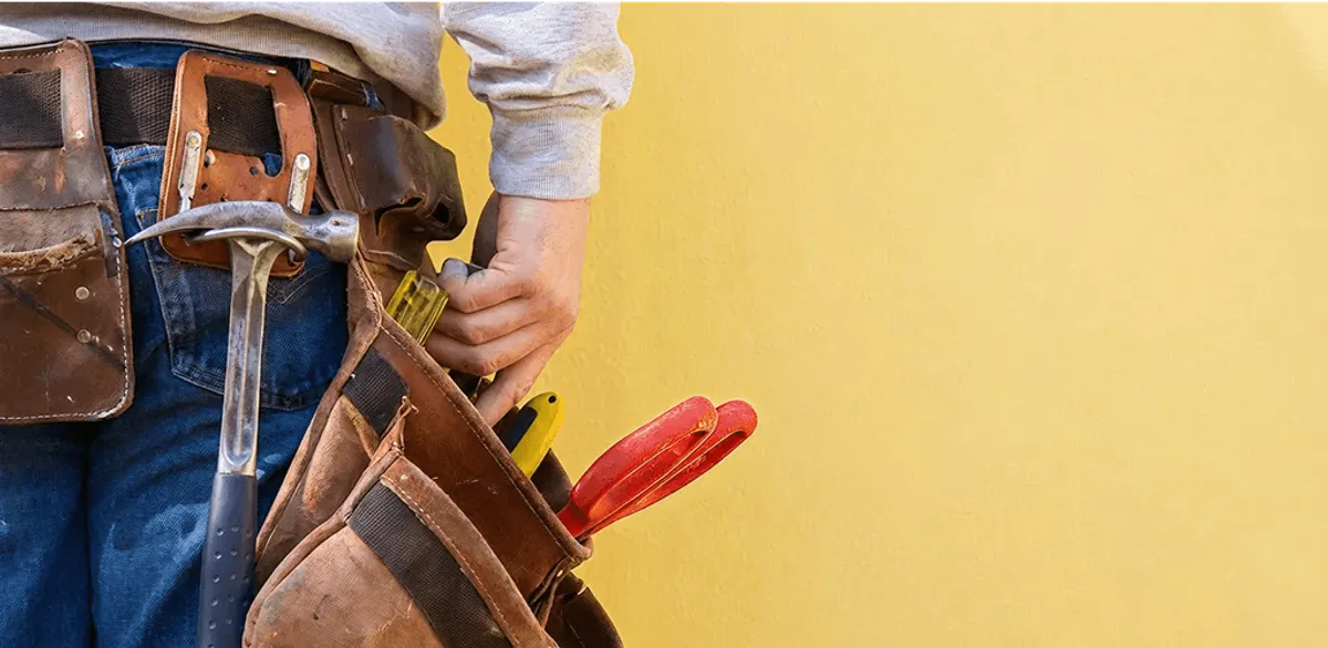 Handyman with tool belt ready for home repairs and maintenance in Bloomington, IN